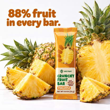 Crunchy Fruit Bar Pineapple — wrapped bar beside fresh fruit, 88% fruit in every bar
