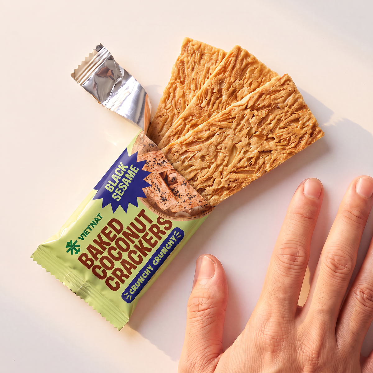 One snack pack and crackers shown next to a hand for size, Black Sesame