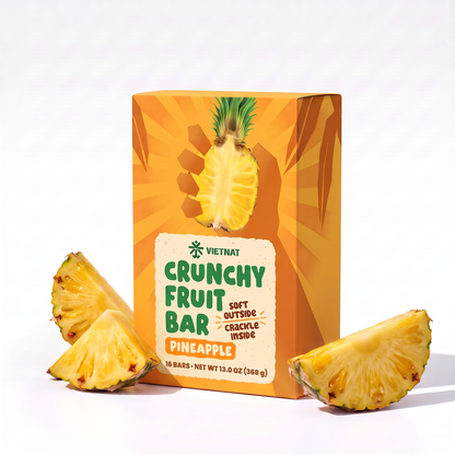 Crunchy Fruit Bar Pineapple box of 16 bars next to fresh pineapple