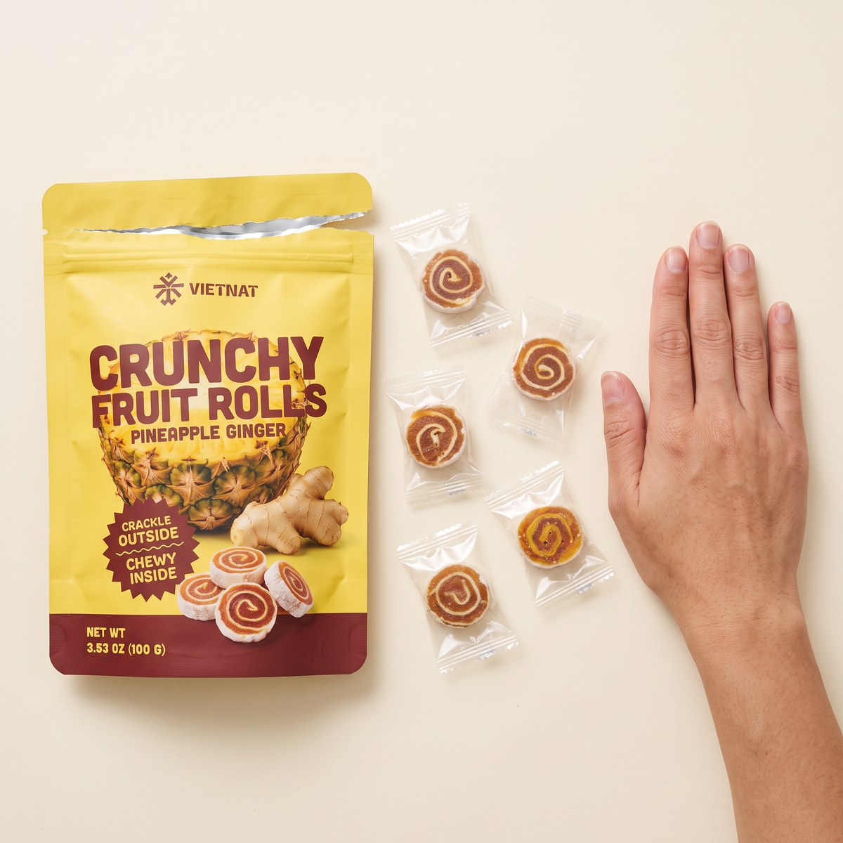 Pineapple ginger fruit rolls next to a hand to show size, about 1¼ in across
