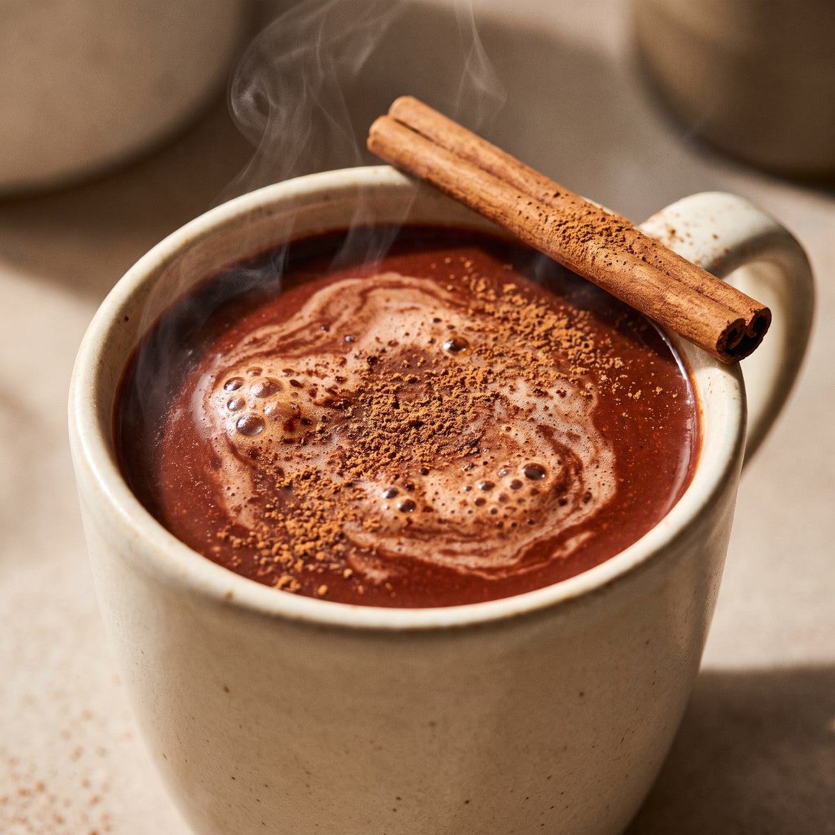 Close-up of a mug of thick drinking chocolate with a cinnamon quill resting on the rim