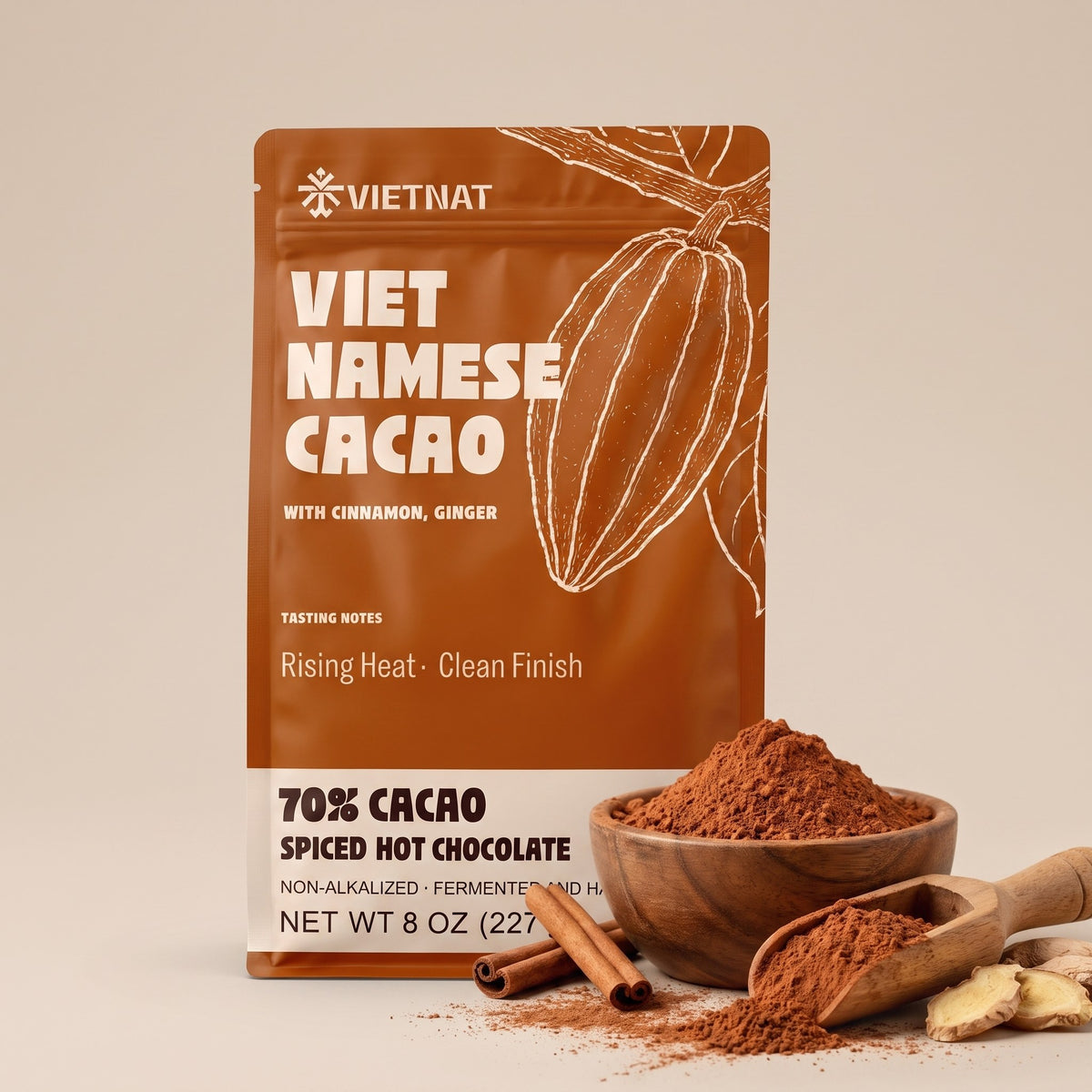 Fine cacao and spice grind in a wooden bowl beside the pouch, with cinnamon quills and fresh ginger