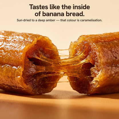 Close up of a whole dried banana pulled apart, chewy amber texture